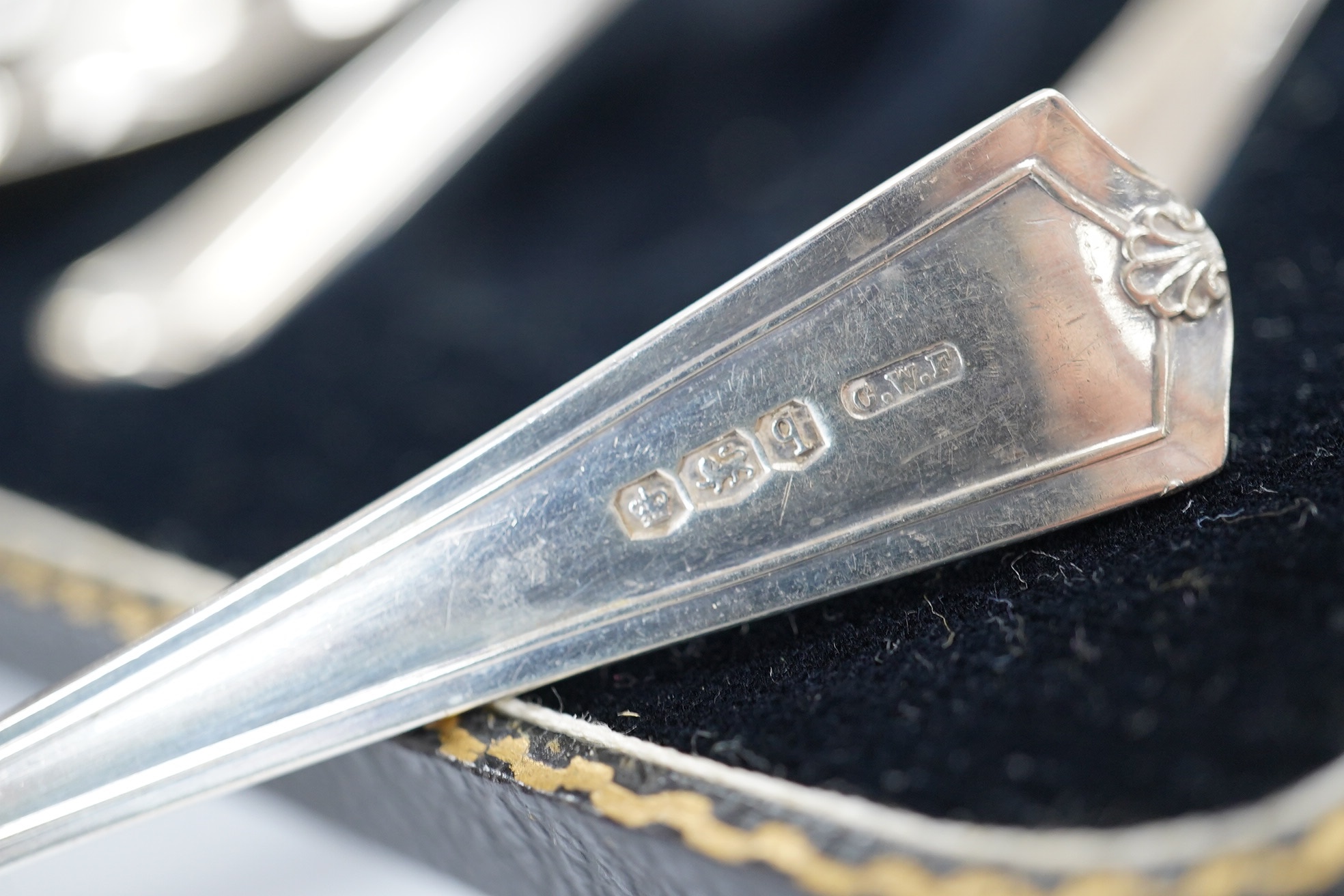 A cased set of eight George V silver grapefruit spoons, Sheffield, 1933 and a pair of silver spill vases, 17.5cm. Condition - poor to fair